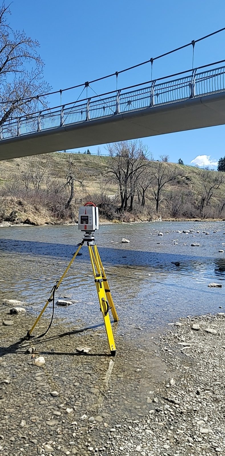 Terrestrial laser scanning beside a river beneath a pedestrian bridge